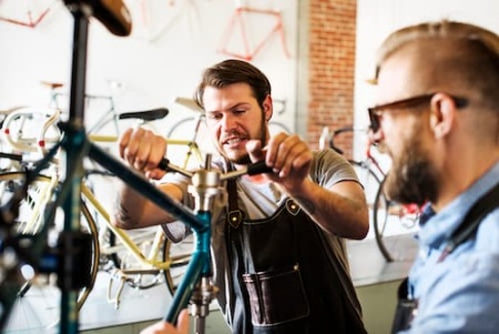 two-men-in-a-cycle-repair-shop-looking-at-a-bicyc-2025-04-05-02-36-22-utc.jpg